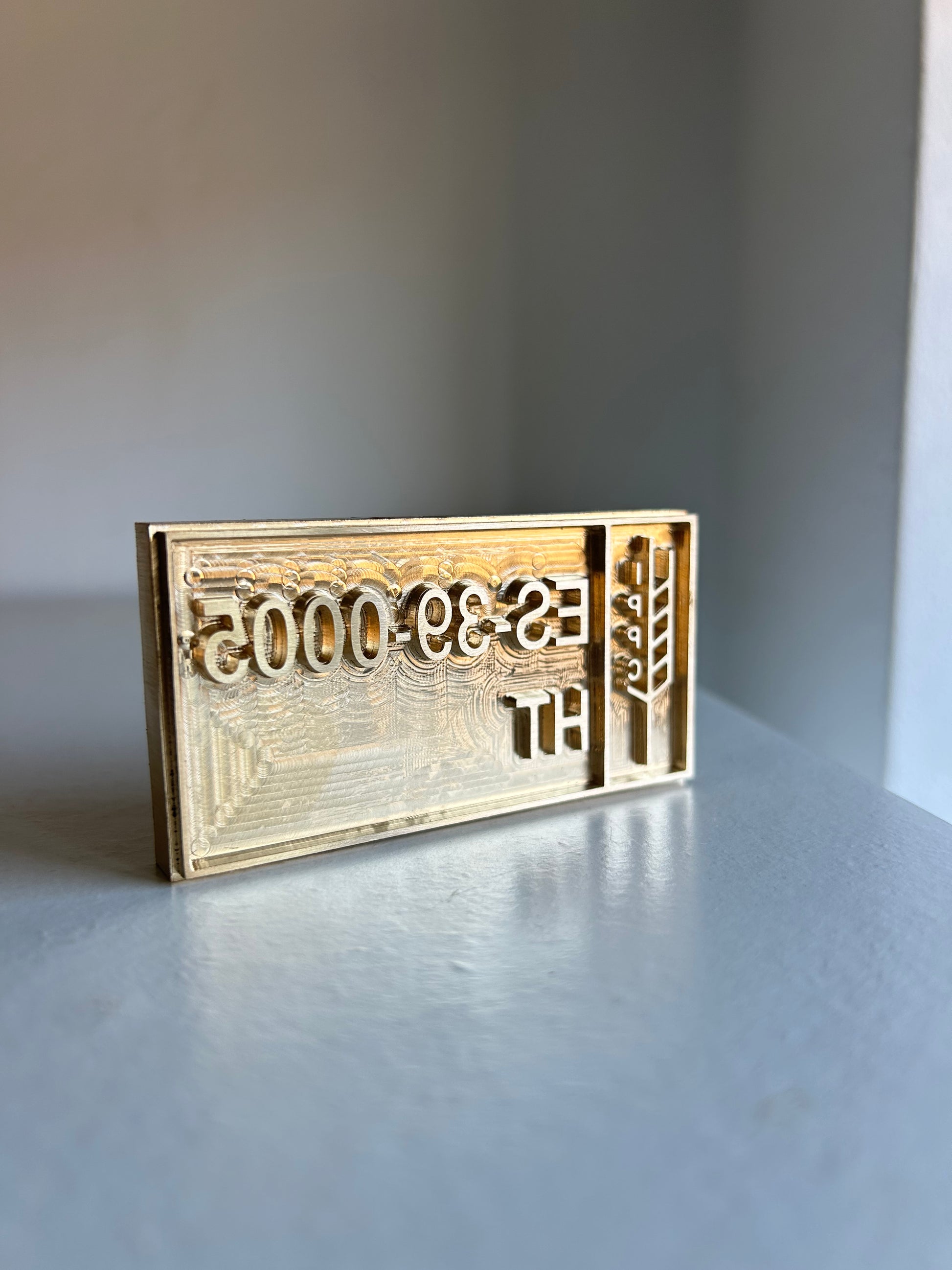 Close-up of engraved brass ISPM 15 pallet stamp with registration code